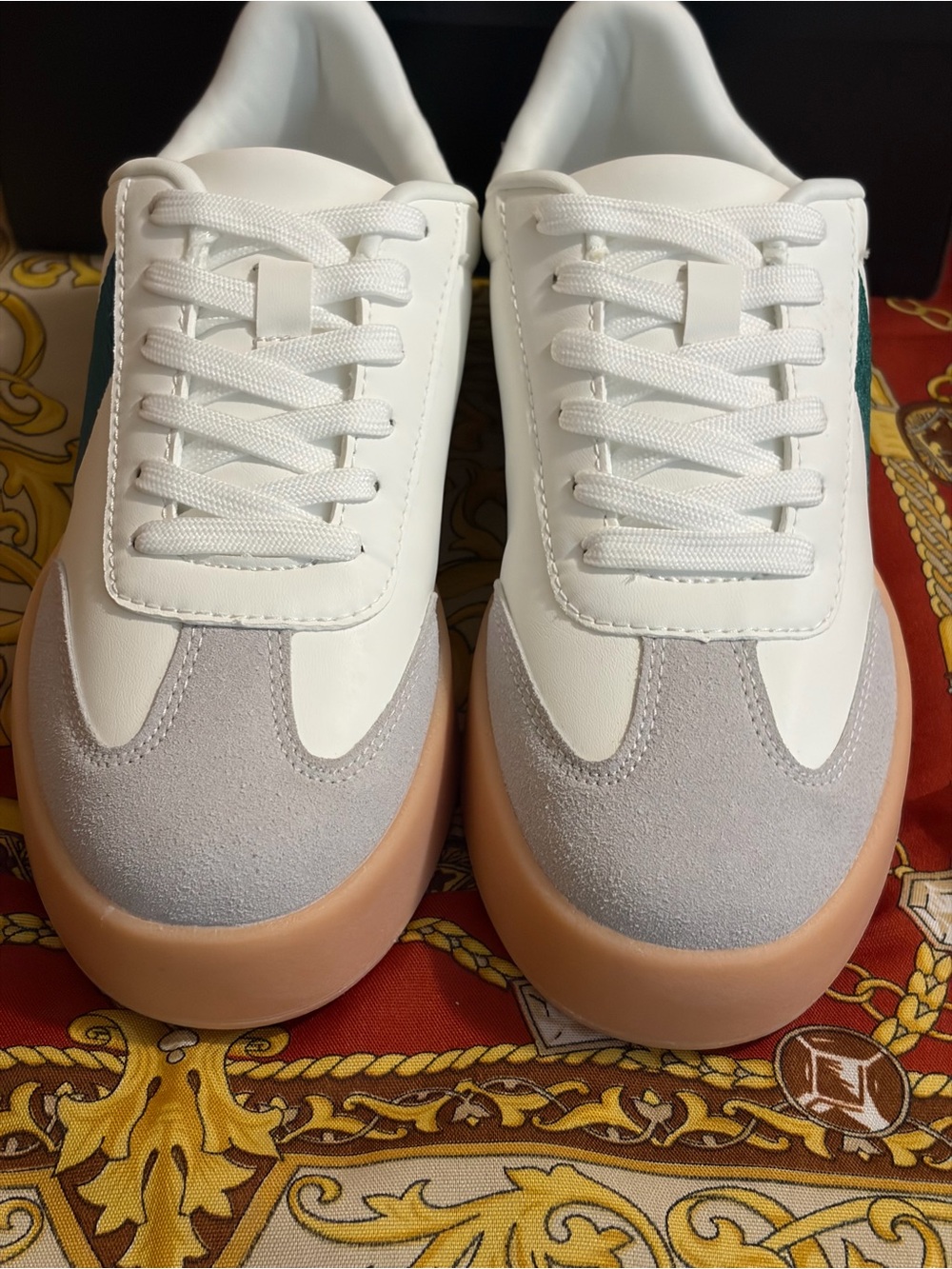 Clean white faux leather upper accented with dark green side panels and matching